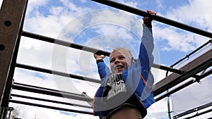 Little boy hanging on monkey bars