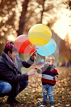 Little boy. Happy childhood. child boy with a bunch of balloons in their hands in yellow autumn park. Family