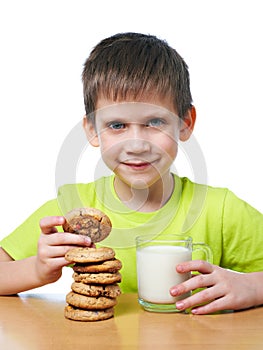 Little boy has breakfast cookies and milk isolated