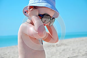 Little boy has put on mother`s glasses