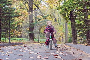 Little boy having fun on bikes in autumn forest. Selective focus