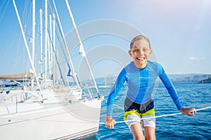 Little boy having fun on board of yacht on summer cruise. Travel adventure, yachting with child on family vacation. photo