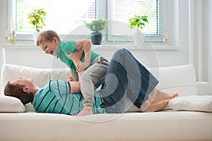 Little boy having fun with father at home photo