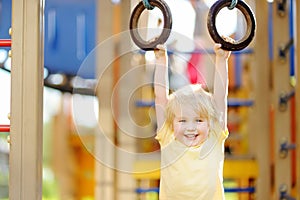 Little boy having fun on outdoor playground. Summer active sport leisure for kids