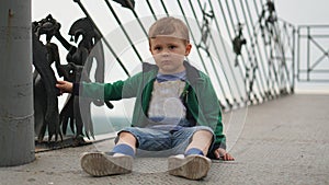 Little boy having fun on a playground outdoors in summer. Toddler on a slide