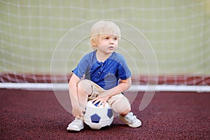 Little boy having fun playing a soccer/football game on summer day