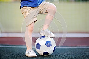 Little boy having fun playing a soccer/football game on summer day