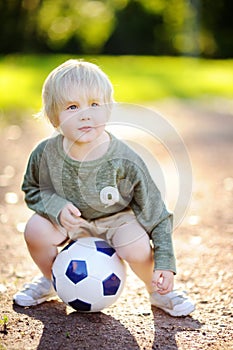 Little boy having fun playing a soccer/football game on summer day