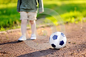 Little boy having fun playing a soccer/football game on summer day