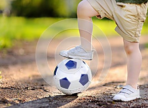 Little boy having fun playing a soccer/football game on summer day