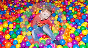 Little boy having fun in a pool of colorful balls in the entertainment center