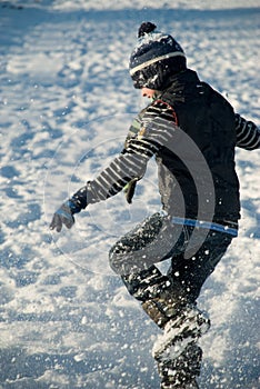 Little boy having fun, running in the snow