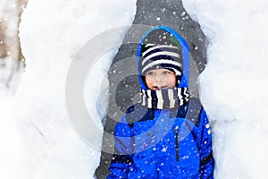 Little boy having fun in winter snow cave
