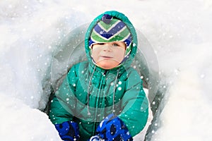 Little boy having fun in winter snow