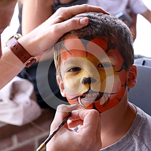 Little boy having his face painted