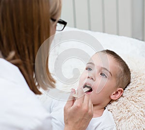 Little boy having his throat examined by health professional