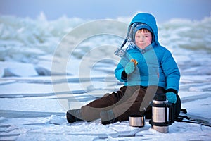 Little boy having a picnic on winter vacation