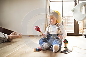 Little boy with headphones, listening music, playing musical toy