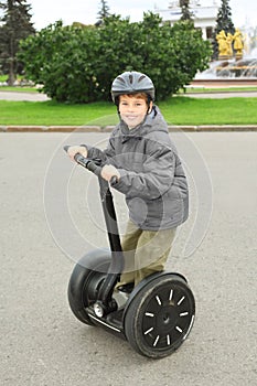 Little boy in helmet ride on segway photo