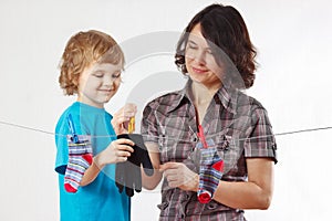 Little boy helps her mother to hang up your glove and socks