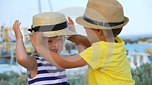 Little boy helps to dress a little girl`s hat