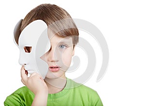 Little boy hides half of face behind mask