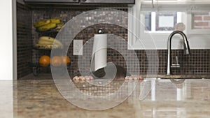 Little boy hiding in the kitchen under the counter top table and looking out from under the table. preschooler laughing