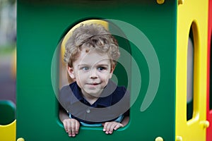 Little boy hiding in a playhouse