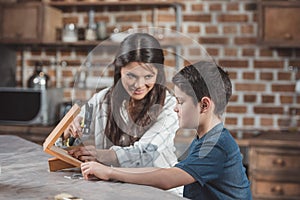 Little boy and his beautiful mother using hammer to build a