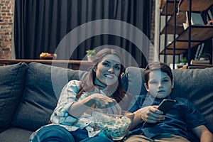 Little boy and his beautiful mother watching tv