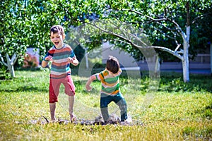 Little boy and his brother play in summer park. Children with co