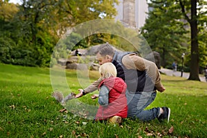 Little boy with his father feeding squirrel in central park, Manhattan, New York. Quality family time