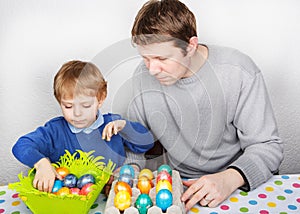 Little boy and his mother being happy about selfmade Easter eggs