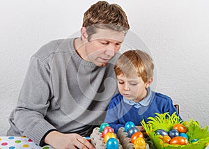 Little boy and his mother being happy about selfmade Easter eggs