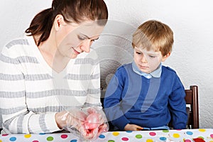 Little boy and his mother being happy about selfmade Easter eggs