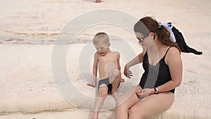 Little boy with his mother playing in water in travertine pools in Pamukkale.