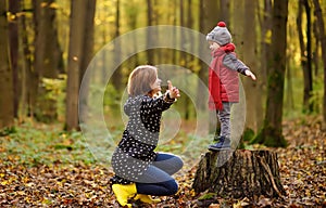 Little boy with his young mother during stroll in the forest