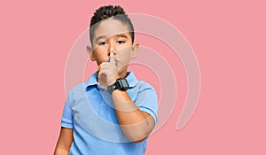 Little boy hispanic kid wearing casual clothes asking to be quiet with finger on lips
