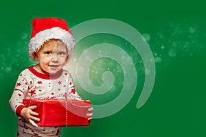 Little boy hold present box wearing Santa hat