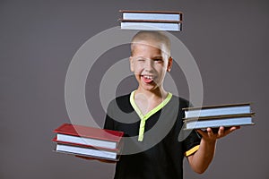 little boy hold the stacks of books in your hands and on your head