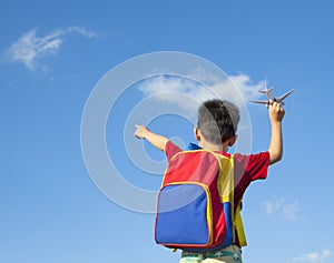 Little boy holding a airplane toy and point