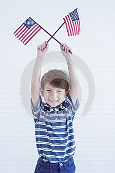 A little boy holding american flags