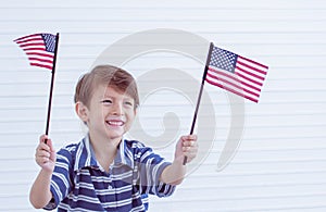 A little boy holding american flags