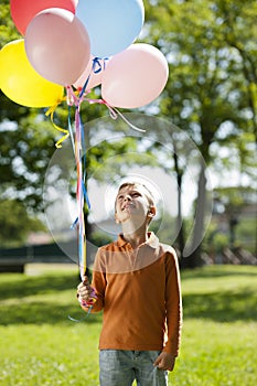 Little boy holding balloons