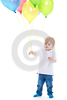 Little boy holding balloons on a white background.