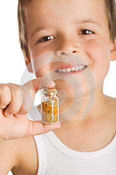 Little boy holding bottle of pollen