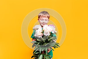 Little boy holding a bouquet of beautiful flowers in his hands, mother`s day, March 8, father`s day