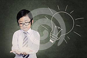 Little boy holding bright light bulb