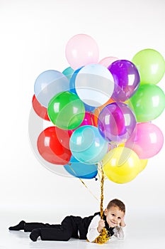 Little boy holding colorful balloons