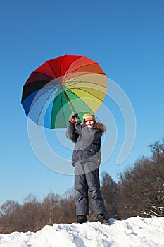 Little boy holding colorful umbrella in winter